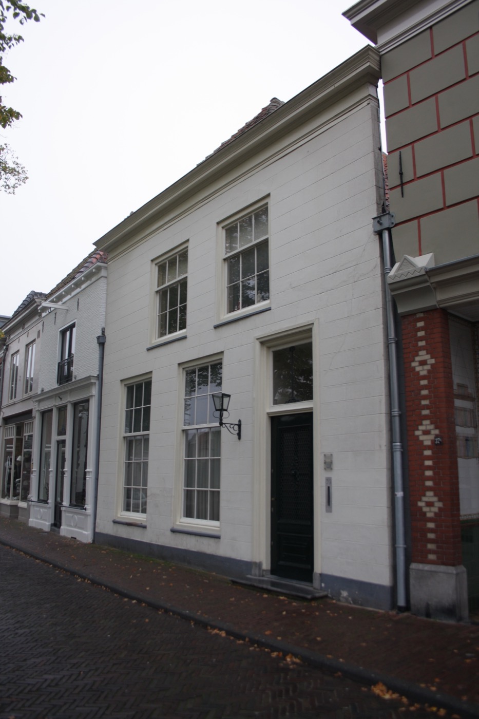 De gepleisterde voorgevel van Havik 39, met hoge ramen en een donkere voordeur, gefotografeerd in 2010